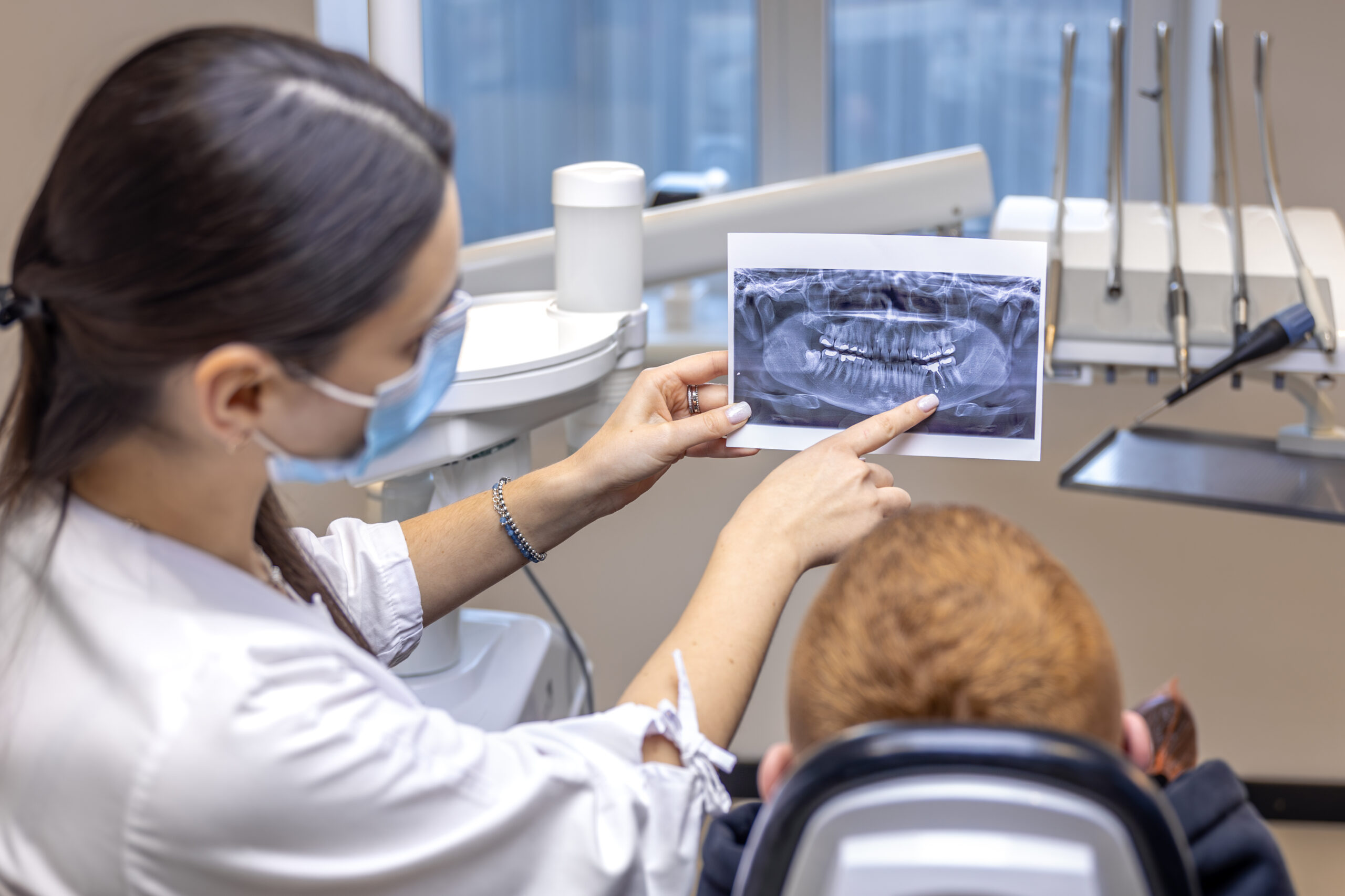 Why Some Ann Arbor Patients Choose Sedation for Endodontic Care Young female dentist showing a patient a dental x-ray. Dentistry concept. High quality photo. Dentist at work. Dentist and patient.
